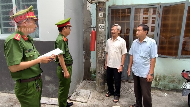 trung uy vo dinh tan ngoai cung ben trai cung voi chi huy cong an phuong tham hoi nam tinh hinh trong nhan dan 640x360