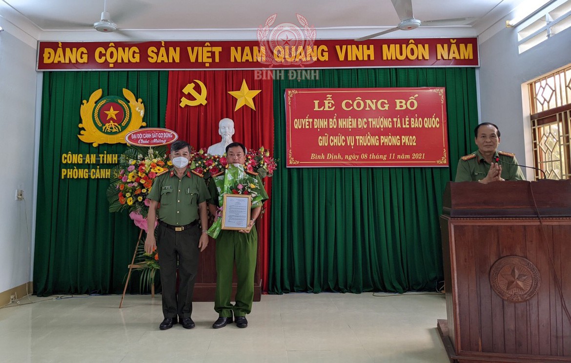 Đồng chí Đặng Hồng Thọ trao quyết định và tặng hoa đồng chí Lê Bảo Quốc